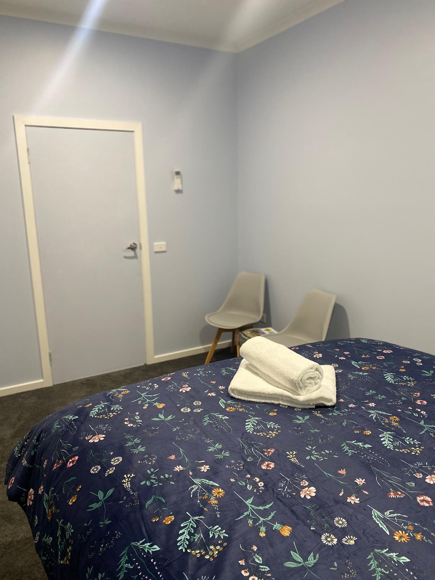 Queen bedroom with fresh towels and modern seating at Bright Accommodation Park caravan park, Bright VIC