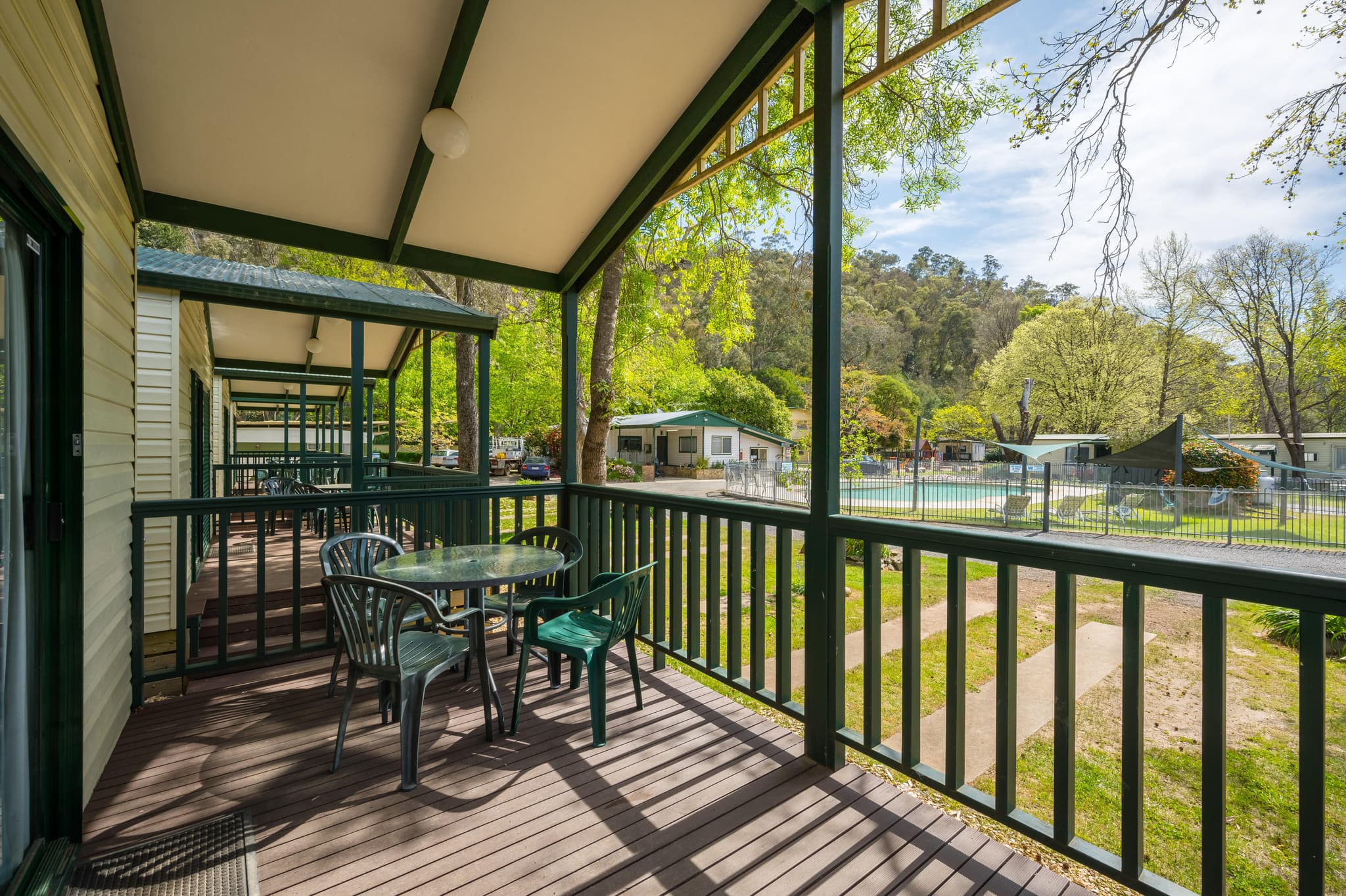 Screened outdoor deck with table and chairs at Supreme Villas, Bright Accommodation Park, Great Alpine Road