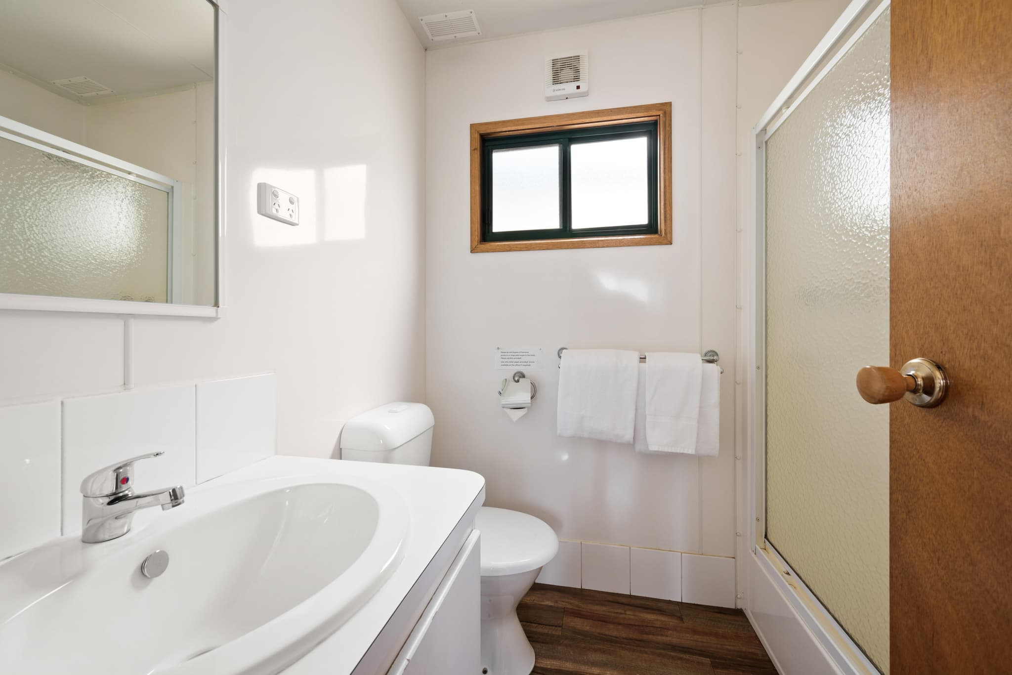Modern bathroom with white vanity, toilet and shower in Supreme Villa at Bright Accommodation Park caravan park