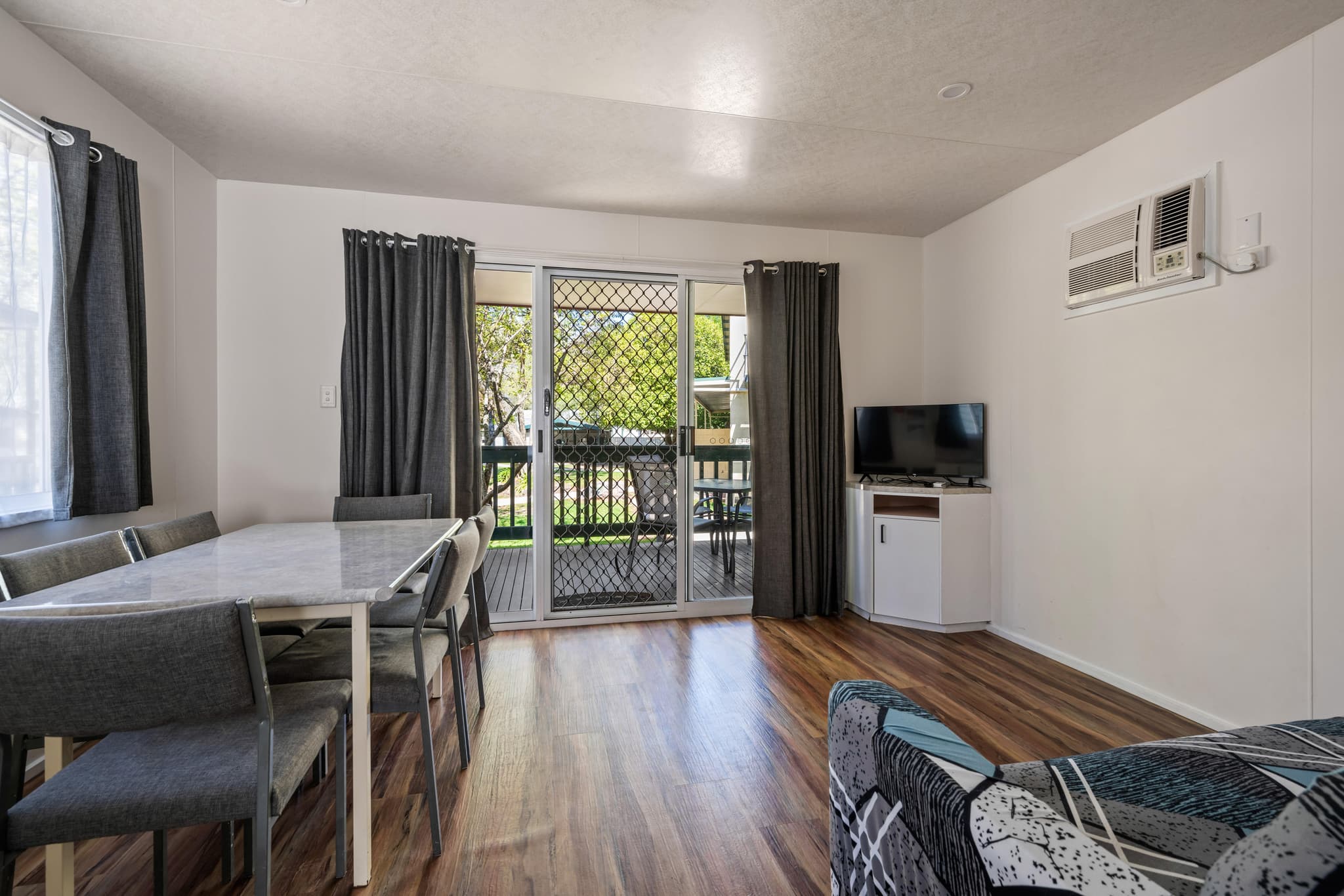 Bright Accommodation Park Bogong Cabin interior with dining area, lounge, and balcony access in Bright VIC
